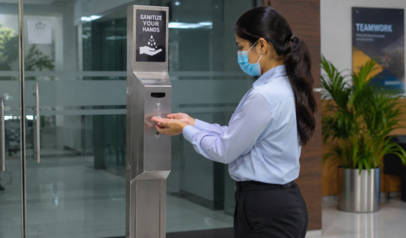 Touch-free hand sanitizer stand in office lobby.